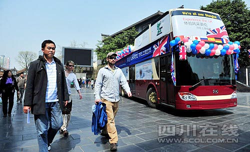 在寬窄巷子，幾位外國游客從世博大巴旁經(jīng)過