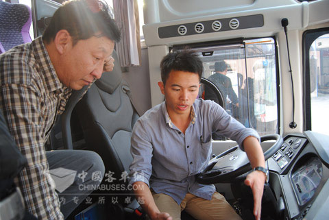 工作人員為長治汽運總經(jīng)理張志斌（左）講解龍翼車聯(lián)網(wǎng)科技平臺